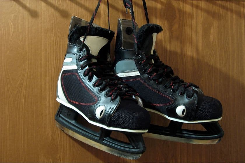 A pair of hockey skates hanging in the locker room.